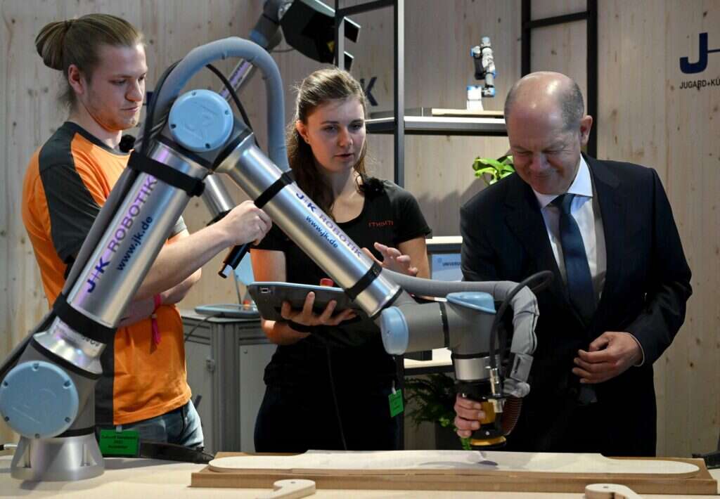 Olaf Scholz examines an AI-powered robot